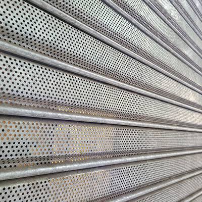 Cortina metálica microperforada instalada en fachada comercial